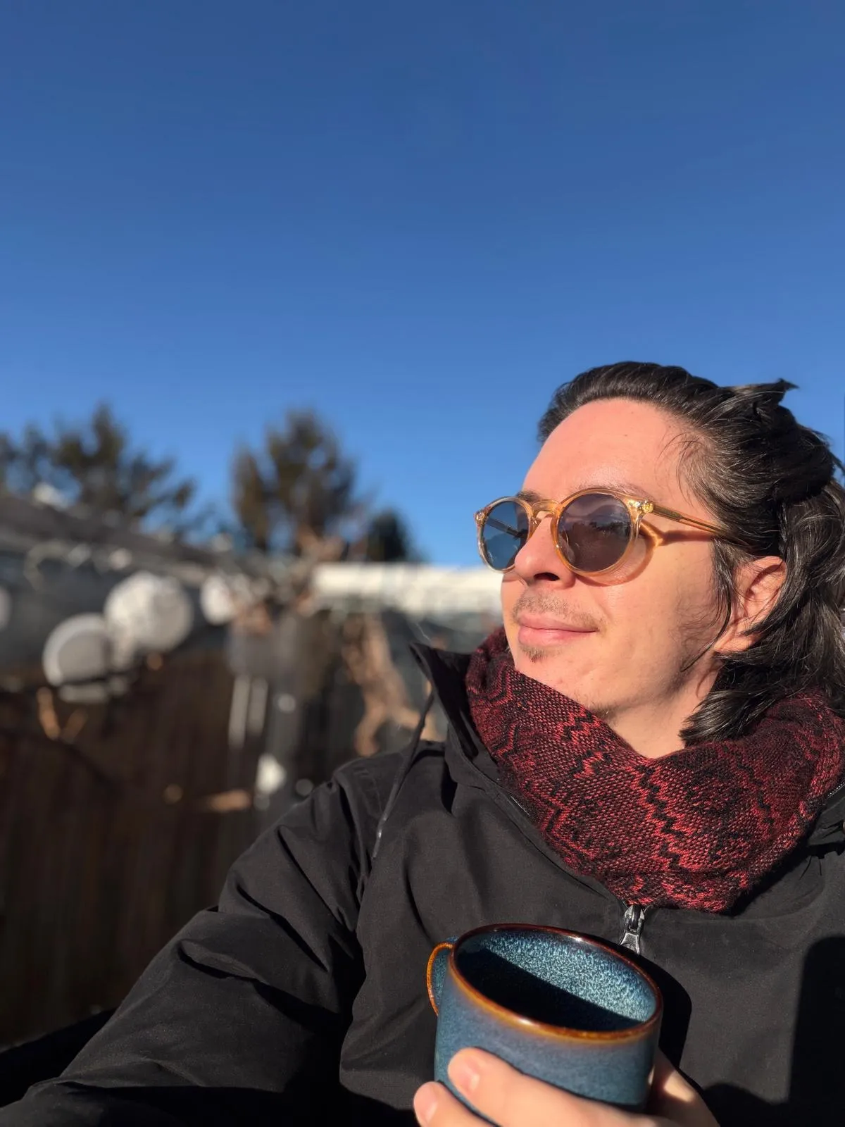 Dominik Vsetecka with sunglasses and a cup of coffee in the winter sun